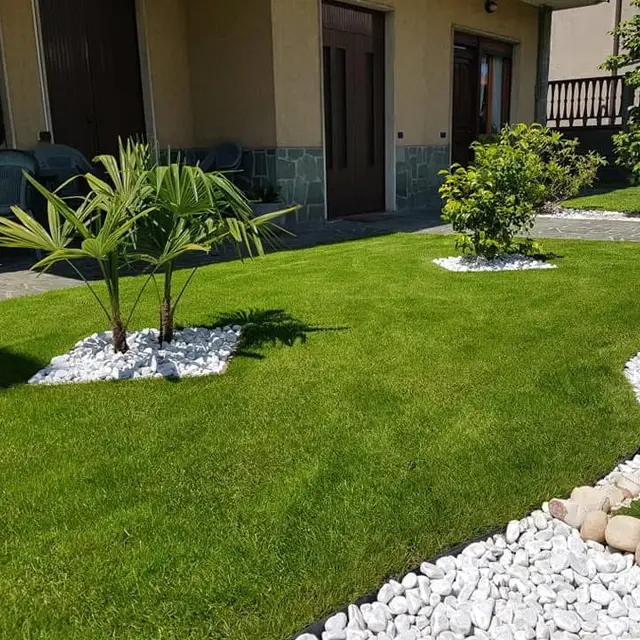Giardino con prato tagliato e sassi bianchi